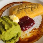 A plate with shapes of pureed fish and green beans, with cranberry jelly, a dollop of margarine, and dill on top.