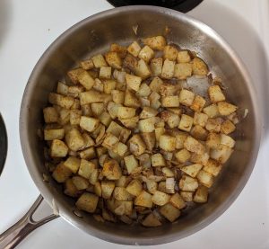 potatoes and onions in a pan covered in spices